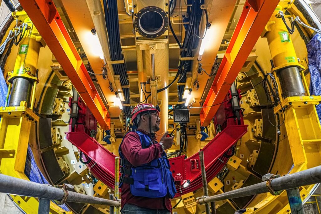 Trabajador con casco dentro de un equipo industrial de acceso reducido